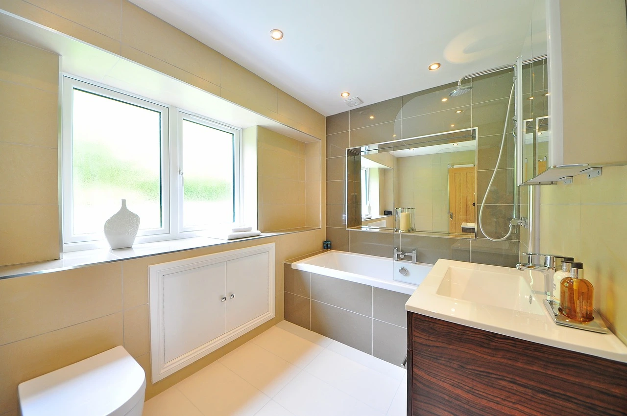 Bright modern bathroom in Chicago with soaking tub, glass shower panel, large window, and updated vanity finishes.
