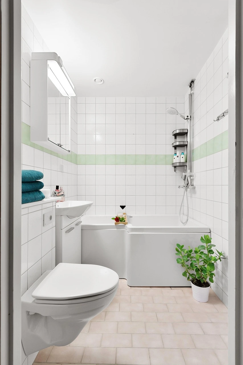 Classic Chicago bathroom with tub-and-shower combo, white tile walls, and soft green accent trim.