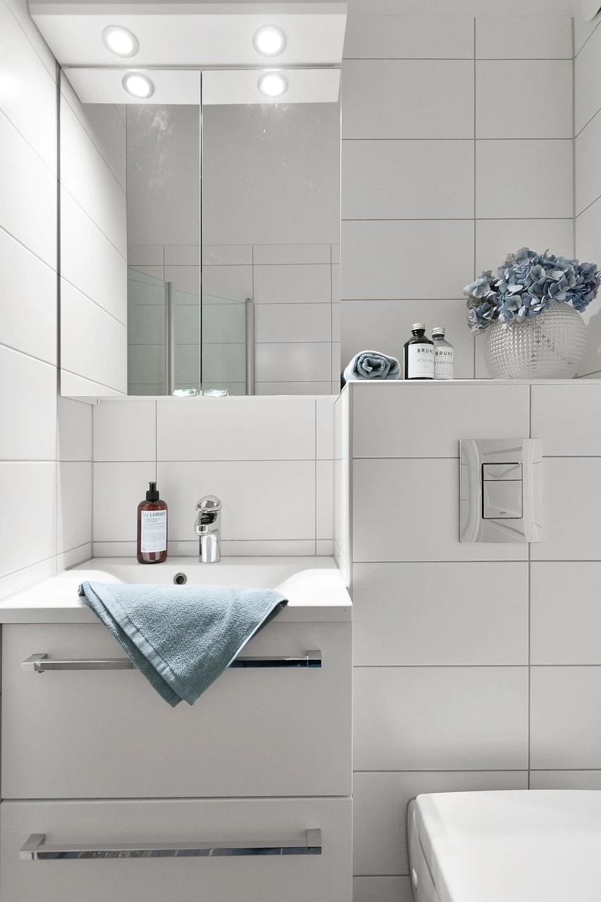 Modern white-tile bathroom remodel in Chicago with clean tile lines, updated vanity, and frameless glass details.